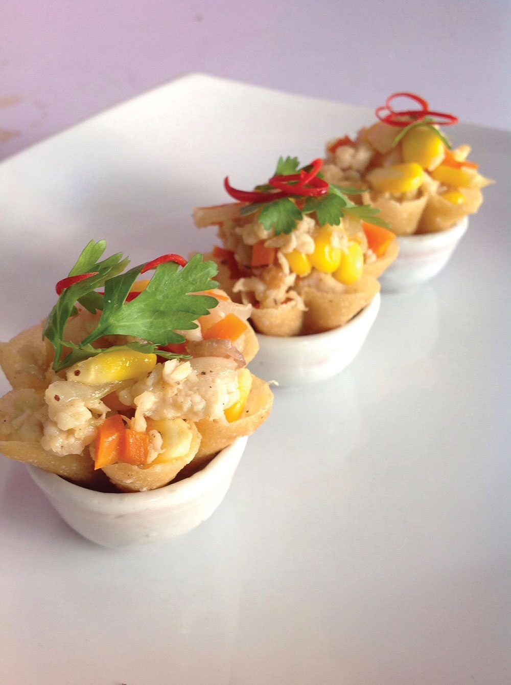  หากกล่าวถึง ร้านอาหารสไตล์เชฟเทเบิล หลายคนคงจะนึกถึงเมนูอาหารญี่ปุ่น หรืออาหารสไตล์ยุโรปสุดหรู ที่รังสรรค์โดยเชฟมากฝีมือที่มาในราคาแพงหูฉี่  แต่สำหรับ ‘ร้านขนมอมยิ้ม’ กาญจนบุรี เป็นร้านอาหารไทยสไตล์เชฟเทเบิล ร้านแรกและร้านเดียวในจ.กาญจนบุรี มี เชฟแมนนี่ ผู้ซึ่งมีความเชี่ยวชาญด้านอาหารไทยและขนมไทย รับหน้าที่เป็นทั้งเจ้าของร้านและเชฟประจำร้าน