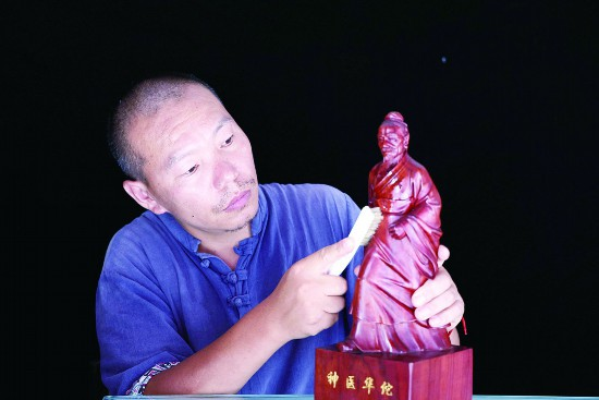 ฟู่ อี้เจี๋ย กำลังทำงานแกะสลักไม้ (ภาพถ่าย/www.bozhou.cn)