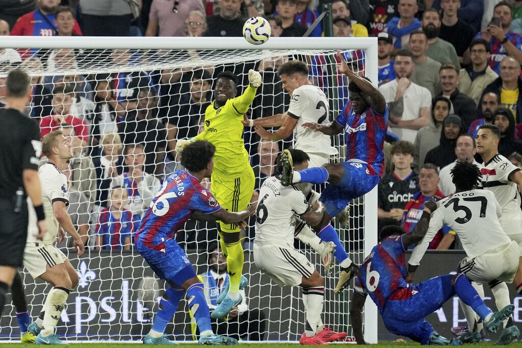 Manchester United goalkeeper Andre Onana punches the ball away