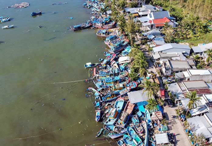 ภาพถ่ายทางอากาศจากโดรนแสดงให้เห็นเรือประมงที่จมอยู่ใต้ซากเรือตามถนนสายหลักหลังจากถูกพายุไต้ฝุ่นคัลแมกีซัดเข้าฝั่งที่หมู่บ้านชาวประมงหวุงเฉาในภาคกลางของเวียดนาม ซึ่งฟาร์มกุ้งมังกรหลายร้อยแห่งถูกซัดหายไปหรือได้รับความเสียหาย ในเขตซวนเกา จังหวัดดั๊กลัก ประเทศเวียดนาม