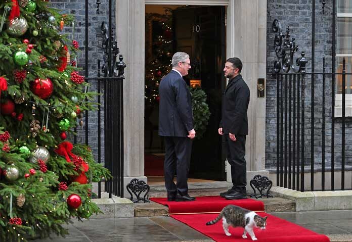 ผู้นำยุโรปเห็นพ้อง - นายกรัฐมนตรีเคียร์ สตาร์เมอร์ของอังกฤษ ทักทายประธานาธิบดีโวโลดิมีร์ เซเลนสกีของยูเครน ที่หน้าประตูบ้านเลขที่ 10 ถนนดาวนิง กรุงลอนดอน วันจันทร์ที่ 8 ธันวาคม พ.ศ. 2568 โดยมีแลร์รี แมว หัวหน้าทีมสำรวจเมาส์ของสำนักงานคณะรัฐมนตรีเดินผ่านไป
