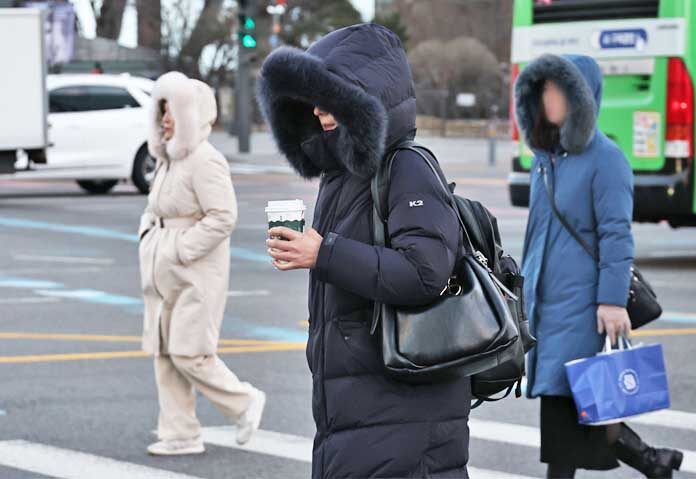 ผู้คนเดินถนนในใจกลางกรุงโซลเมื่อวันศุกร์ที่ผ่านมา ต่างสวมเสื้อแจ็กเก็ตหนาๆ ท่ามกลางอากาศหนาวจัด
