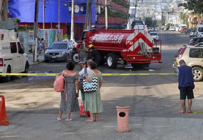 ประชาชนเฝ้าดูเจ้าหน้าที่ดับเพลิงปฏิบัติงานในพื้นที่ที่หม้อแปลงไฟฟ้าล้มทับรถพยาบาลหลังเกิดแผ่นดินไหวในเมืองอะคาปุลโก ประเทศเม็กซิโก เมื่อวันที่ 2 มกราคม 2026
