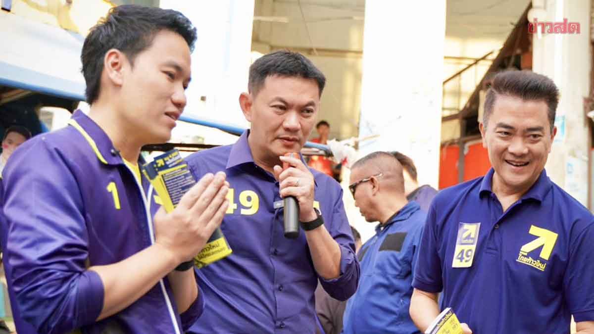 Take Me Down If You Can! Market Vendor Cheers on Dr. Ae, Smiling and Highlighting Flood Solutions