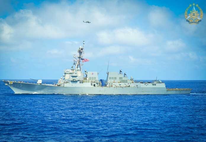 เรือพิฆาตติดขีปนาวุธนำวิถีชั้น Arleigh Burke รุ่น USS Dewey (DDG 105) เตรียมพร้อมขณะที่เฮลิคอปเตอร์ MH-60R Seahawk บินผ่าน เพื่อเตรียมการสำหรับการฝึกยกพลขึ้นบกข้ามดาดฟ้า (Cross-Deck Landing) ในระหว่างกิจกรรมความร่วมมือทางทะเลพหุภาคีครั้งที่ 15 ซึ่งจัดขึ้นระหว่างวันที่ 20 ถึง 26 กุมภาพันธ์ 2026