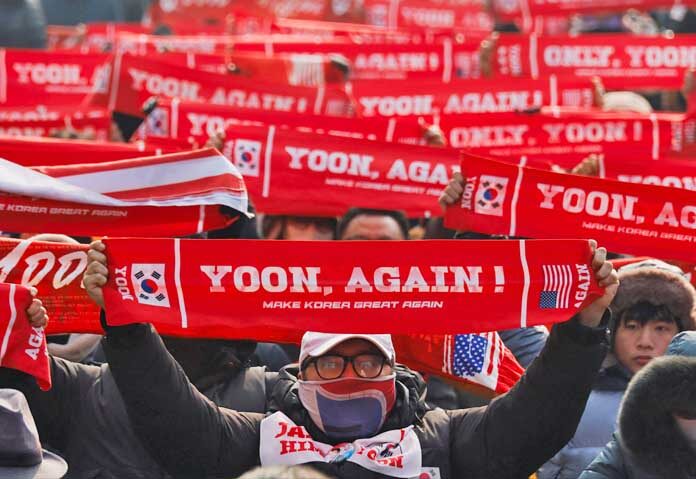 กลุ่มผู้ประท้วงฝ่ายขวาจัดรวมตัวกันเพื่อสนับสนุนอดีตประธานาธิบดีเกาหลีใต้ ยุน ซุก ยอล ถือป้ายที่มีสโลแกน ก่อนที่รถบัสที่บรรทุกยุน ซุก ยอล จะมาถึงเพื่อรับฟังคำตัดสินครั้งแรกในคดีที่รวมถึงการขัดขวางการจับกุม ซึ่งเชื่อมโยงกับการประกาศกฎอัยการศึกของเขา ที่ศาลในกรุงโซล ประเทศเกาหลีใต้ เมื่อวันที่ 16 มกราคม 2026