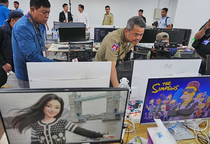 บุน โสเศคา รองผู้บัญชาการตำรวจนครหลวงพนมเปญ หัวหน้าหน่วยรักษาความปลอดภัย ตรวจสอบอุปกรณ์ที่ยึดได้จากการบุกตรวจค้นศูนย์ฉ้อโกงในกรุงพนมเปญ ประเทศกัมพูชา เมื่อวันพุธที่ 11 มีนาคม 2569