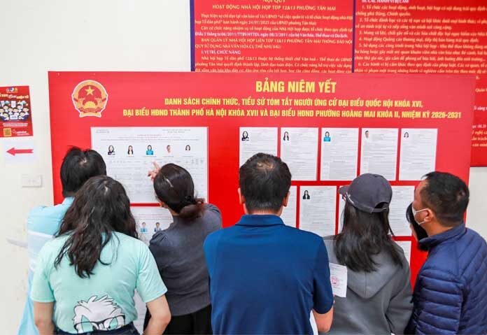 ผู้มีสิทธิเลือกตั้งตรวจสอบประวัติของผู้สมัครก่อนลงคะแนนเสียงเลือกตั้งผู้แทนในรัฐสภาและสภาประชาชนในกรุงฮานอย ประเทศเวียดนาม วันอาทิตย์ที่ 15 มีนาคม 2569
