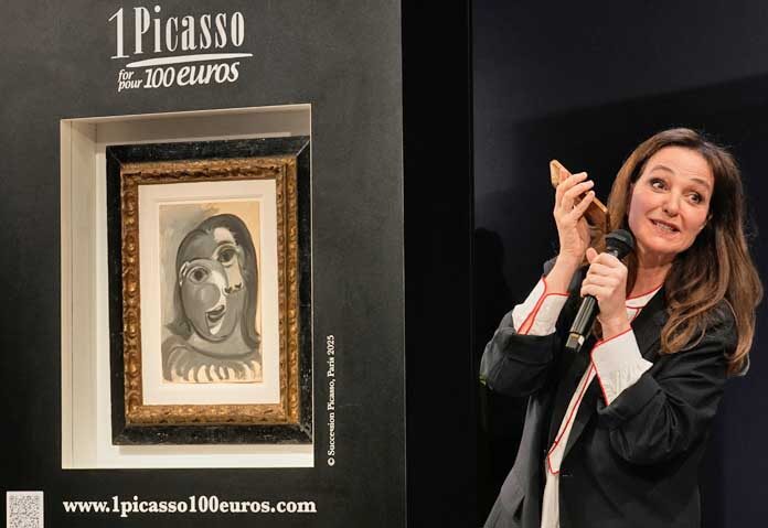 เพริ โคชิน (ขวา) ผู้ก่อตั้งโครงการ "1 Picasso for 100 euros" กล่าวสุนทรพจน์ข้างภาพวาด "ศีรษะของสตรี" โดยปาโบล ปิกัสโซ ซึ่งวาดในปี 1941 ระหว่างการจับฉลากที่คริสตี้ส์ในปารีส เมื่อวันอังคารที่ 14 เมษายน 2026 เพื่อสนับสนุนการวิจัยโรคอัลไซเมอร์