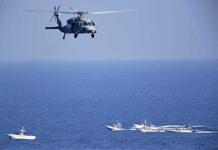 ภาพถ่ายจากแฟ้มภาพ - เฮลิคอปเตอร์ MH-60 Seahawk ของสหรัฐฯ บินเหนือเรือลาดตระเวนของกองกำลังพิทักษ์ปฏิวัติอิหร่านในช่องแคบฮอร์มุซ เมื่อวันที่ 21 ธันวาคม 2018 นาวิกโยธินหลายพันนาย พร้อมด้วยเครื่องบินรบชั้นนำ เรือรบ และอากาศยานอื่นๆ ของสหรัฐฯ กำลังค่อยๆ สะสมกำลังในอ่าวเปอร์เซีย นี่เป็นสัญญาณว่า แม้สงครามของอเมริกาในภูมิภาคนี้อาจจะจบลงแล้ว แต่ความขัดแย้งกับอิหร่านเกี่ยวกับโครงการนิวเคลียร์ที่กำลังก้าวหน้าก็ยังคงทวีความรุนแรงขึ้นเรื่อยๆ โดยไม่มีทางออกใดๆ ที่มองเห็นได้
