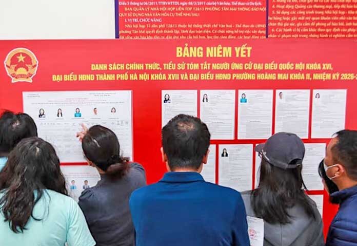 ผู้มีสิทธิเลือกตั้งตรวจสอบประวัติของผู้สมัครก่อนลงคะแนนเสียงเลือกตั้งผู้แทนในรัฐสภาและสภาประชาชนในกรุงฮานอย ประเทศเวียดนาม เมื่อวันที่ 15 มีนาคม 2569
