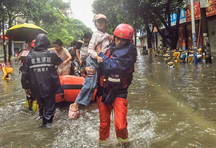 ภาพถ่ายนี้เผยแพร่โดยสำนักข่าวซินหัว แสดงให้เห็นเจ้าหน้าที่กู้ภัยกำลังอพยพประชาชนที่ติดอยู่หลังพายุโซนร้อนเมย์แซคพัดถล่มเมืองฉินโจว มณฑลกว่างซีจ้วง ทางตอนใต้ของจีน
