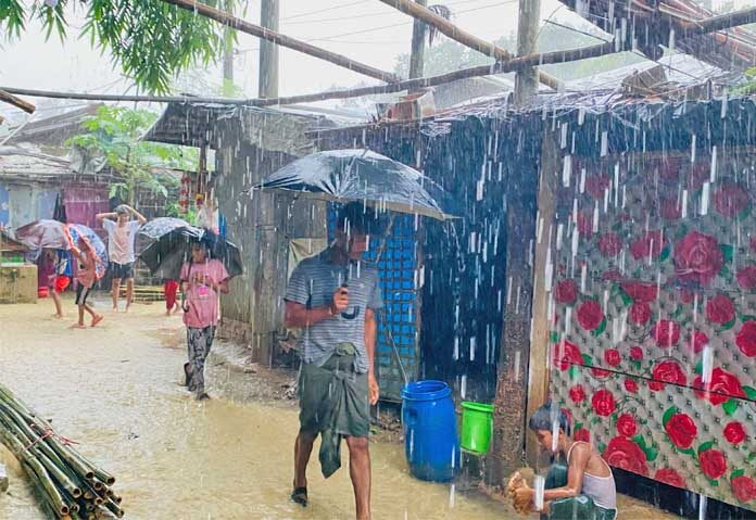ผู้คนเดินฝ่าสายฝนที่ตกหนักในค่ายผู้ลี้ภัยชาวโรฮิงยาในเมืองค็อกซ์บาซาร์ ประเทศบังกลาเทศ