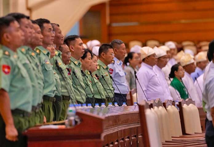 ตัวแทนจากกองทัพและสมาชิกสภาผู้แทนราษฎรของเมียนมายืนต้อนรับนายคิน ยี ประธานสภาผู้แทนราษฎร ระหว่างการประชุมสมัยสามัญ ณ สภาผู้แทนราษฎร ในกรุงเนปยีดอว์ ประเทศเมียนมาร์