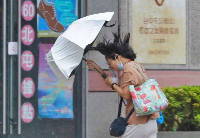 บาหวี่ลดกำลังเป็น “พายุโซนร้อน” - หญิงคนหนึ่งพยายามกางร่มท่ามกลางสายฝนที่เกิดจากพายุไต้ฝุ่นบาบีในเมืองไท่จง ประเทศไต้หวัน เมื่อวันเสาร์ที่ 11 กรกฎาคม 2569