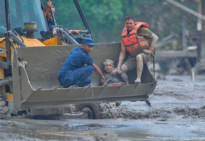 เจ้าหน้าที่กู้ภัยใช้รถขุดดินช่วยเหลือผู้ประสบภัยน้ำท่วมฉับพลันไปยังที่ปลอดภัยตามแนวแม่น้ำตรีศุลี ในเขตนูวาคอต ประเทศเนปาล เมื่อวันพุธที่ 26 สิงหาคม 2569
