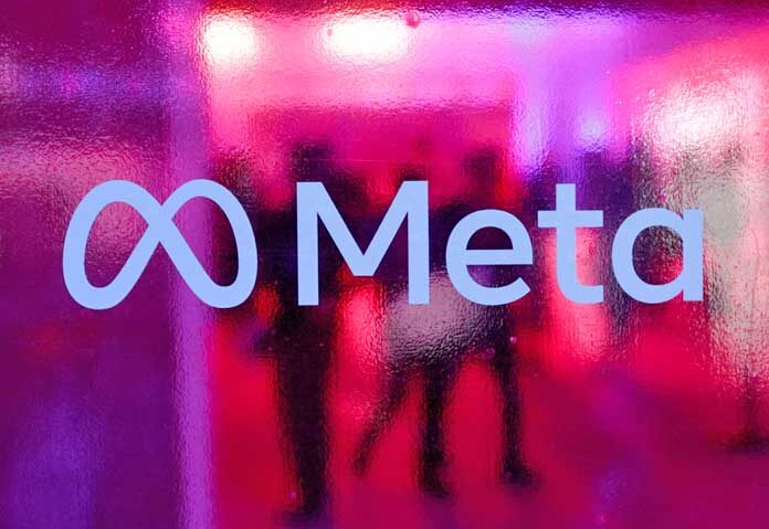 ผู้คนเดินอยู่ด้านหลังโลโก้ของ Meta Platforms ระหว่างการประชุมในเมืองมุมไบ ประเทศอินเดีย เมื่อวันที่ 20 กันยายน 2023