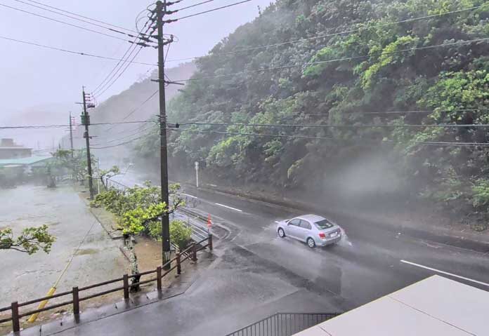 รถยนต์คันหนึ่งแล่นฝ่าลมแรงและฝนขณะที่พายุไต้ฝุ่นดอลฟินกำลังเข้าใกล้ ในนาเซอาซาฮิโช อะมามิ คาโกชิมะ ประเทศญี่ปุ่น เมื่อวันที่ 7 สิงหาคม 2569