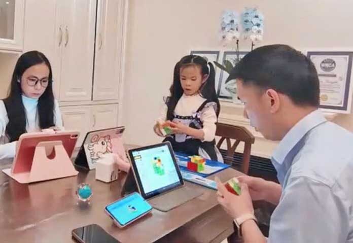 ภาพของเหลียน หยุนจือ วัย 6 ขวบ ขณะกำลังฝึกเล่นรูบิคกับพ่อและแม่ที่บ้านพักในมณฑลเสฉวน ประเทศจีน