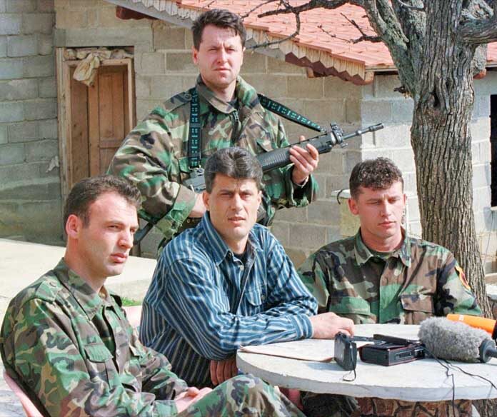 ภาพแฟ้มข่าว - นายฮาชิม ธาชี (Hashim Thaci) หัวหน้าคณะเจรจาฝ่ายชาวแอลเบเนียในโคโซโวและหัวหน้าฝ่ายการเมืองของกองทัพปลดปล่อยโคโซโว (KLA) (บุคคลตรงกลาง) กำลังกล่าวในการแถลงข่าว ณ สถานที่ลับแห่งหนึ่งในภาคกลางของโคโซโว เมื่อวันเสาร์ที่ 13 มีนาคม ค.ศ. 1999