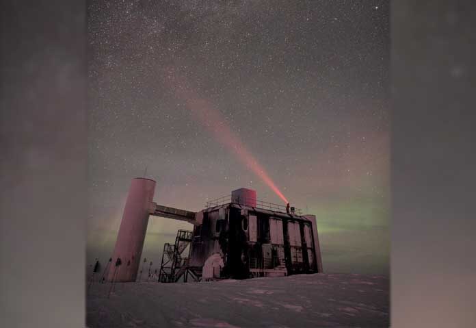 ภาพแฟ้มข่าว: ภาพ IceCube Lab ที่ขั้วโลกใต้ภายใต้ท้องฟ้าที่เต็มไปด้วยดวงดาว โดยมีแสงจากไฟฉายคาดศีรษะส่องขึ้นไปบนท้องฟ้า