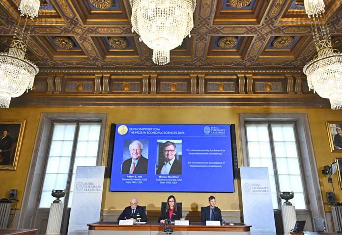 2 นักเศรษฐศาสตร์อเมริกัน - ภาพของ Robert E. Hall และ Michael Woodford ปรากฏบนหน้าจอขณะมีการประกาศชื่อทั้งสองท่านในฐานะผู้ได้รับรางวัล Sveriges Riksbank Prize in Economic Sciences in Memory of Alfred Nobel (รางวัลธนาคารกลางสวีเดนสาขาเศรษฐศาสตร์เพื่อระลึกถึง Alfred Nobel) ณ ราชบัณฑิตยสถานด้านวิทยาศาสตร์แห่งสวีเดน ในกรุงสตอกโฮล์ม ประเทศสวีเดน เมื่อวันจันทร์ที่ 12 ตุลาคม 2026