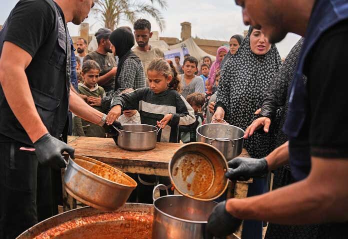 ชาวปาเลสไตน์รับอาหารที่ได้รับบริจาคจากโครงการอาหารโลก (World Food Programme) ณ ค่ายพักพิงผู้พลัดถิ่นในเมืองเดียร์อัลบาลาห์ (Deir al-Balah) ทางตอนกลางของฉนวนกาซา เมื่อวันอาทิตย์ที่ 18 ตุลาคม 2026
